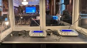 Inside an interpreter booth with interpreter consoles and headsets